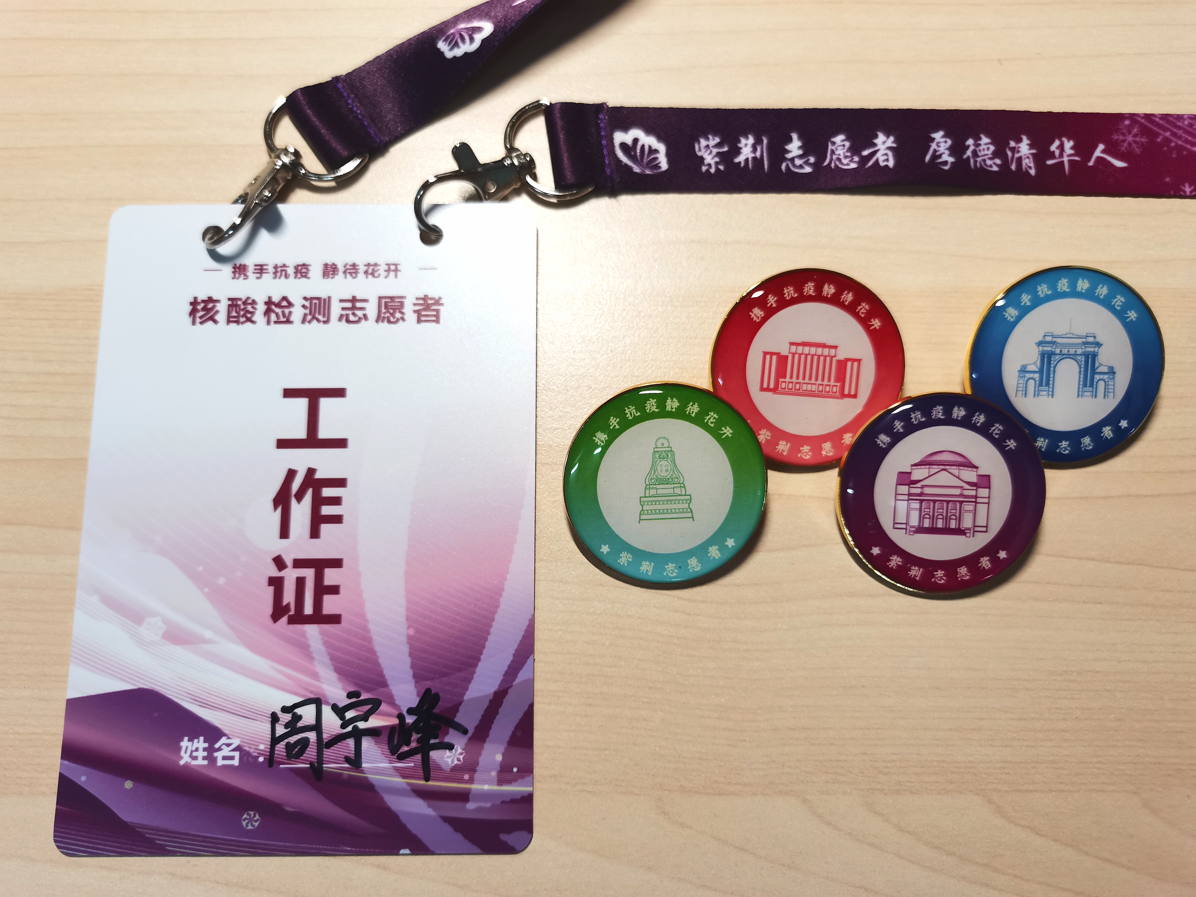 20220520-疫情之下，清华辅导员的“多重身份”-陆心怡-周宇峰设计的志愿者工作证、纪念徽章jpg