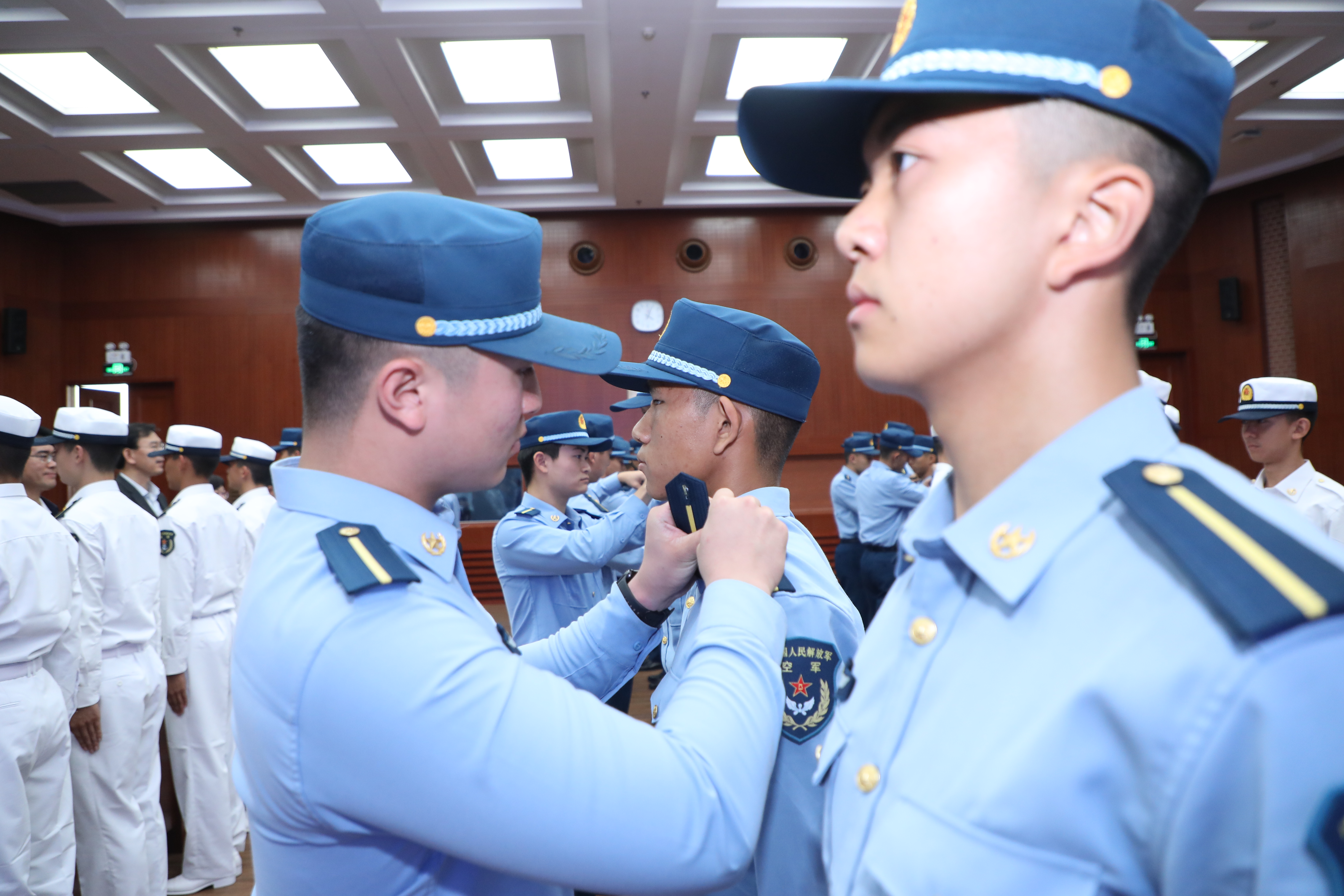 20221007-2022级联合培养飞行学员授衔仪式-曹文鹏-老学员为新学员佩戴简章.jpg