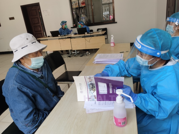 20220603-疫苗接种-XX-接种现场医务人员对史翠英老师进行健康问诊.png