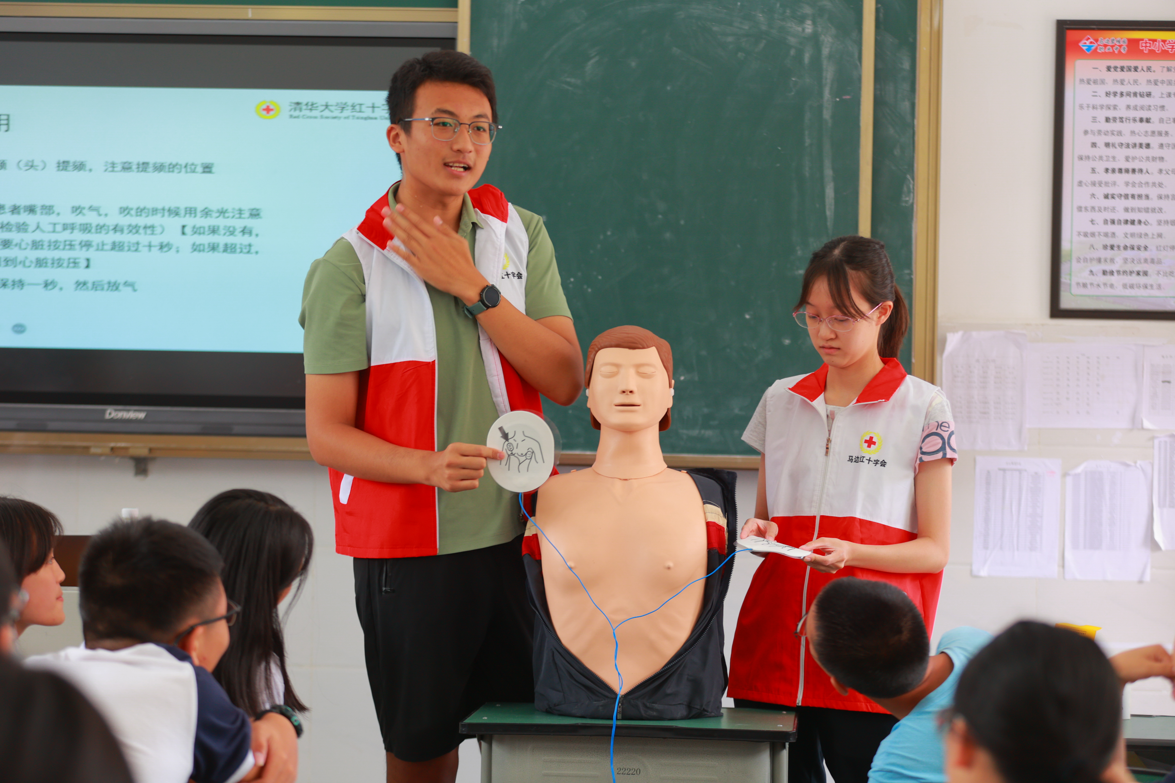 20220802-学生红会支教急救讲堂-郭镕玮-4 红会的老师和清华学生红会的同学们正在讲解AED电极片粘贴位置、演示心肺复苏，同学们跃跃欲试(3).jpg