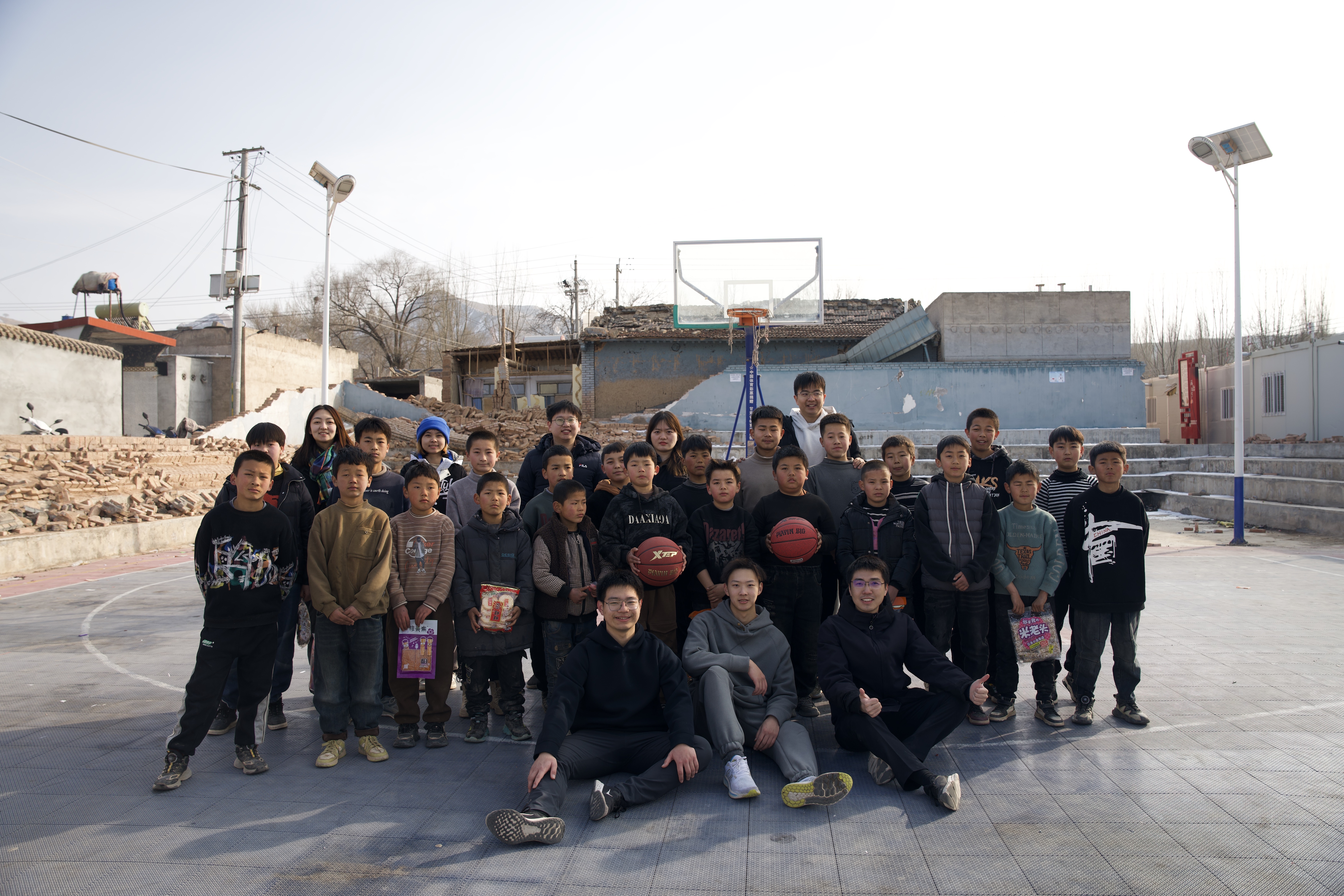 20240219-学思践悟挺膺行,青春建功新时代——2024年清华大学研究生寒假社会实践纪实(一)-“社稷担当·心泽河州”实践支队-支队成员在在震区球场组织开展“青少年村BA”篮球赛.jpg